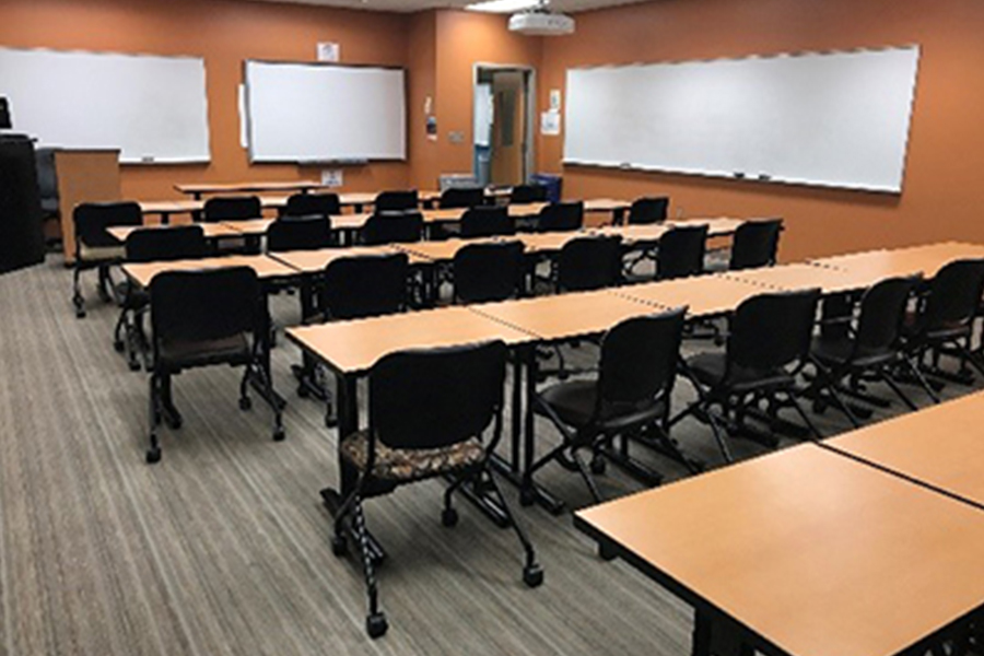 empty classroom with rows of tables and chairs